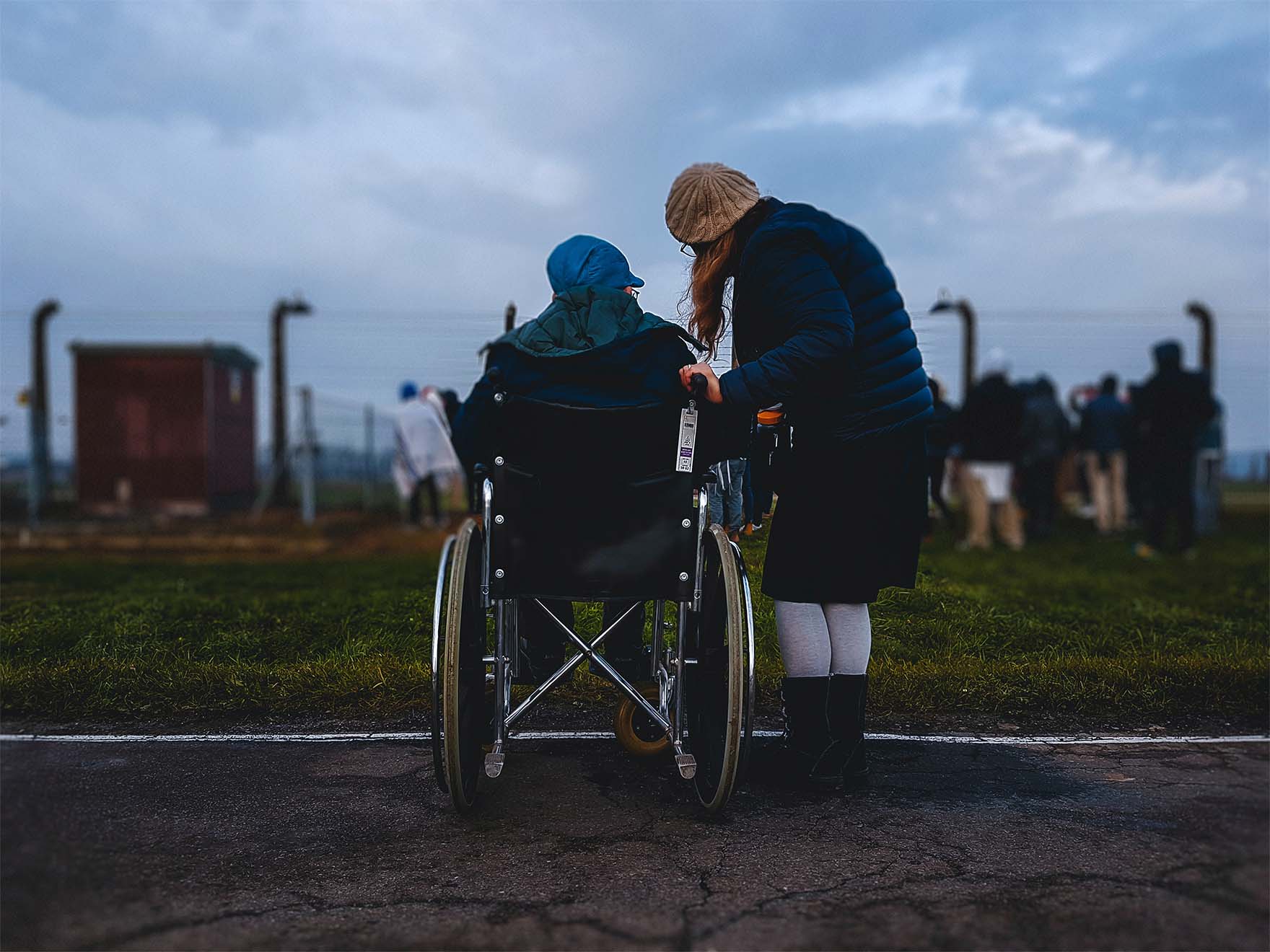 resident wheelchair user outdoors chatting to a carer