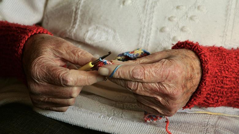 hands knitting with knitting needles and wool