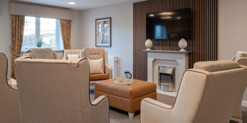 one of our lounges with comfortable chairs and a table in front of the tv