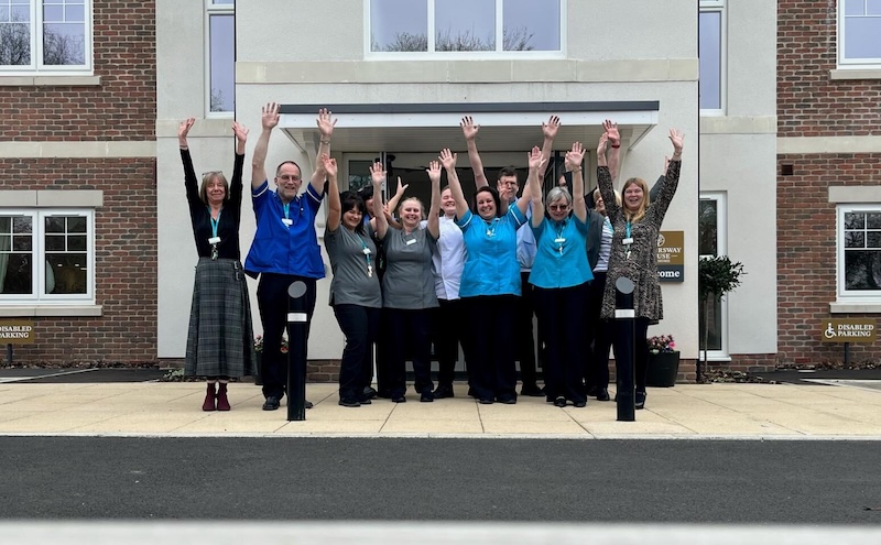 a photo of our team with their arms up on our open day