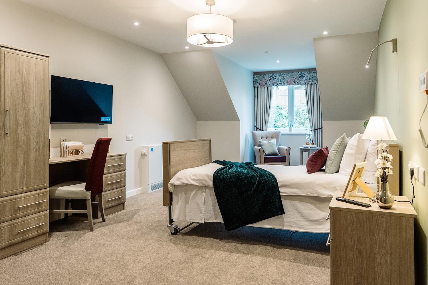 one of our bedrooms with a desk, armchair and storage