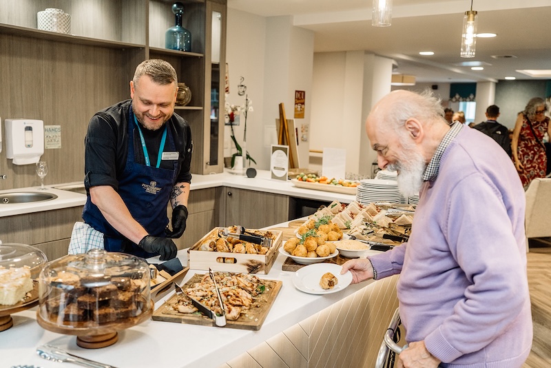 our head chef serving a buffet to resident