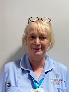 lady with glasses on top of her head posing for staff photo