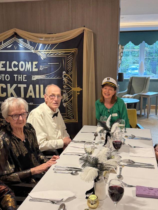 older adults in smart clothes sat at a table
