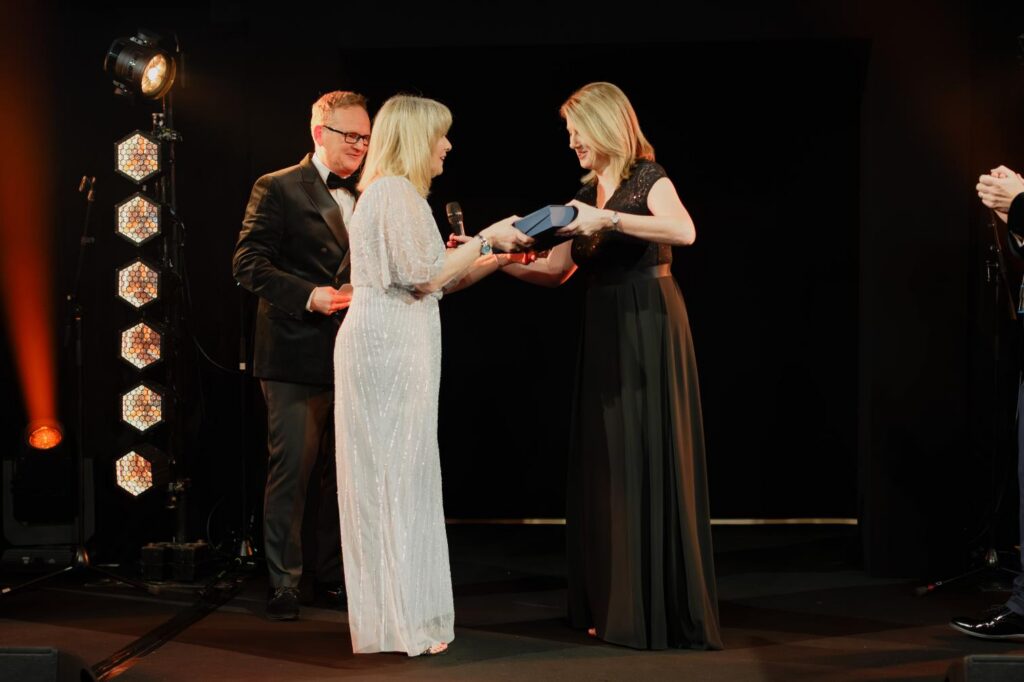blonde lady on stage accepting an award