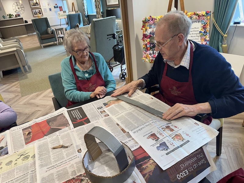 2 of our residents sat making viking helmets around the table