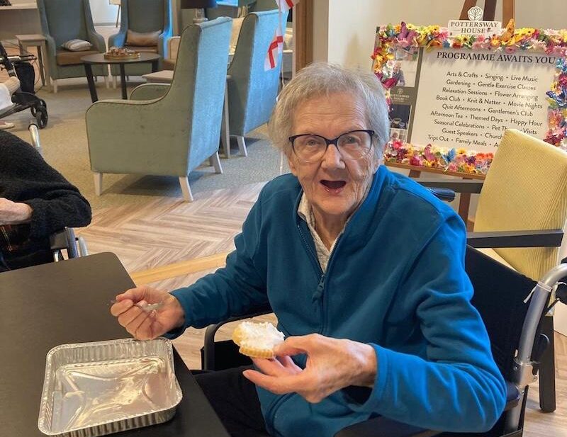 female residents sat down at the table enjoying a biscuit