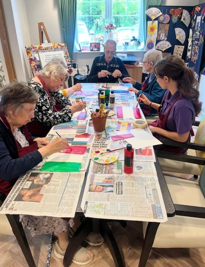 a group of our residents sat at a table doing arts and crafts