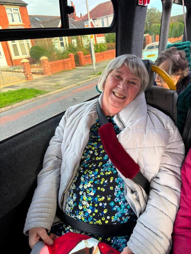 an older lady smiling in a minibus